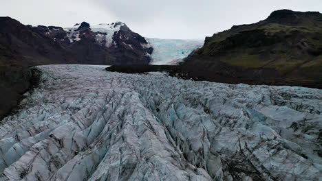 flying over the beautiful caravasses of the svinafellsjokull glacier in south east iceland - aerial shot