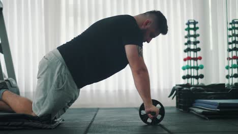 Side-Shot-of-an-Strong-Young-Man-Doing-Abs-Rool-out-Exercise