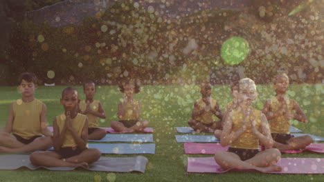 animation of light spots over diverse children practicing yoga and meditating