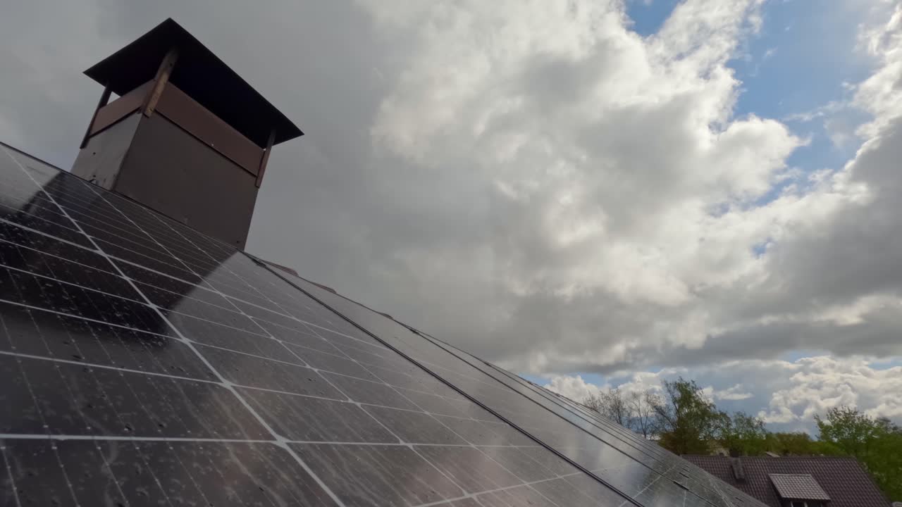 Renewable Energy: Rooftop Solar Panels Against Cloudy Sky with rain and hail Timelapse