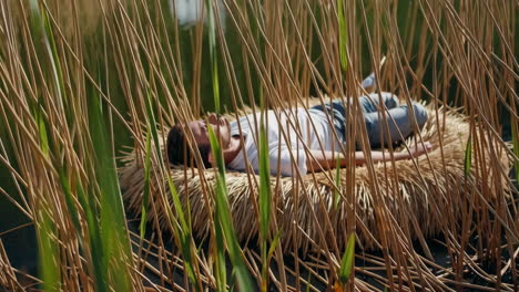 man resting peacefully in a reed nest
