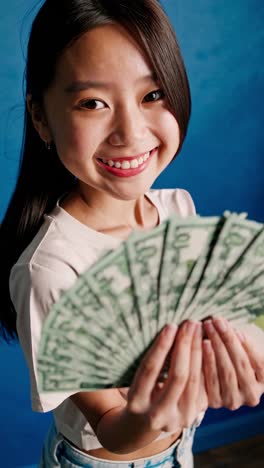 teenage girl holding fan of money