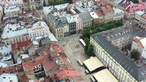 Tourists-walking-the-streets-of-Rynok-Square-in-Lviv-Ukraine-during-sunset,-surrounded-by-city-hall-and-European-buildings