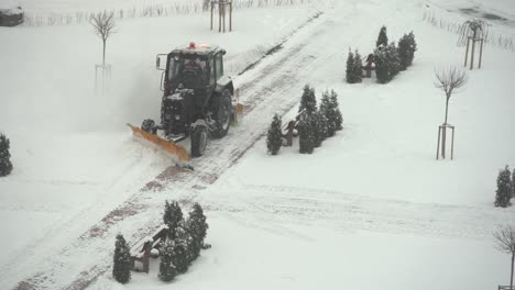 tractor-excavator removes snow in the city yard. work of public utilities