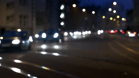 una calle ocupada por la noche donde las luces y los coches están borrosos y sirve como fondo