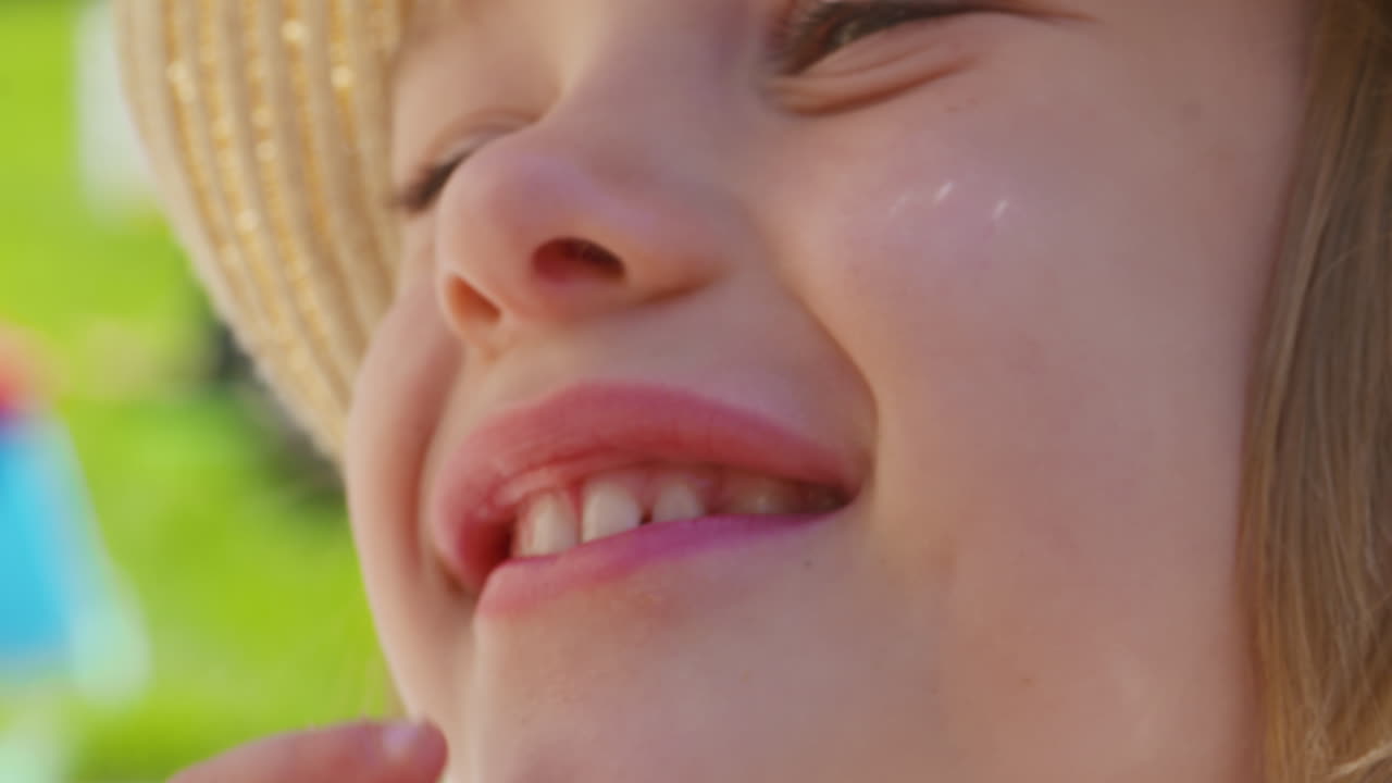 de cerca, adorable niñita riendo y sonriendo bajo el sol de verano