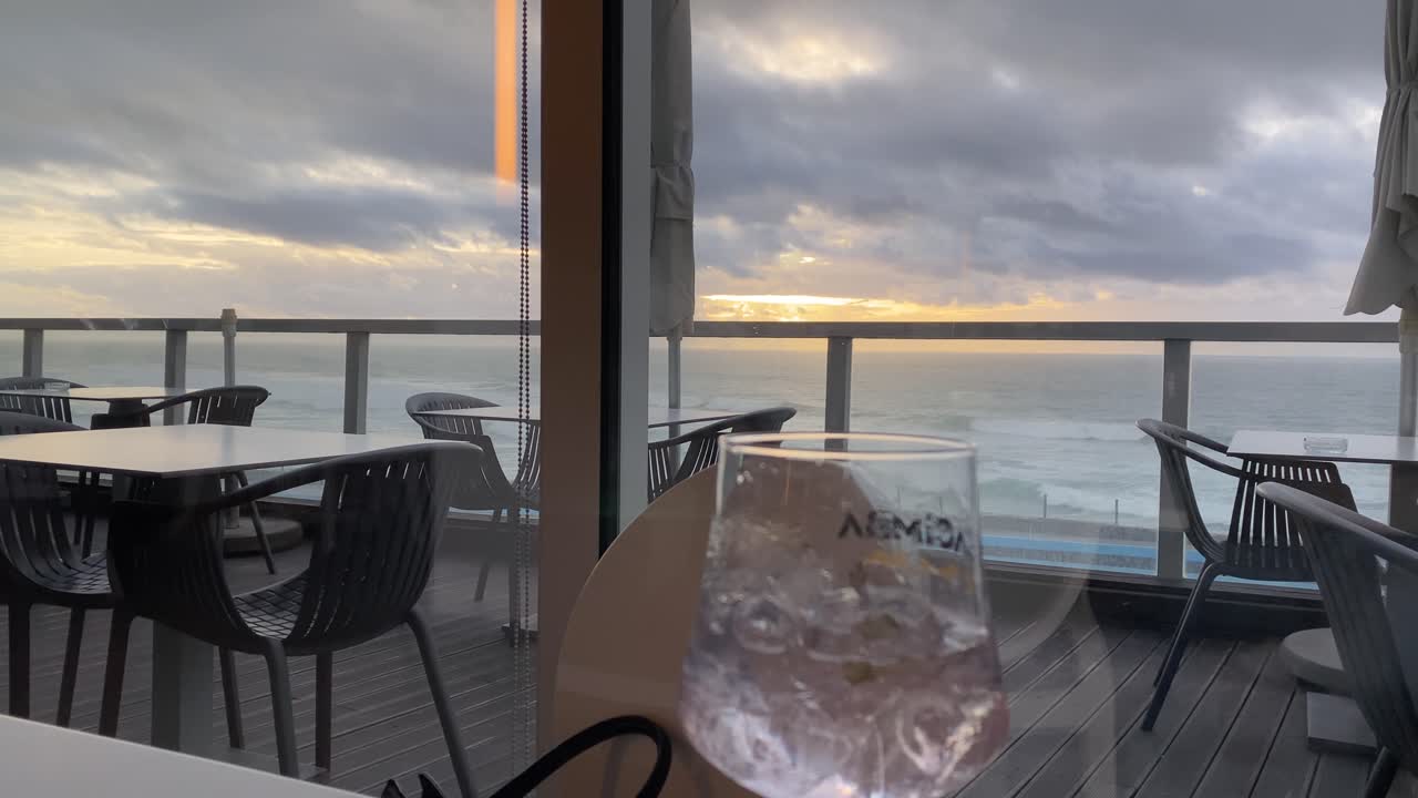 наслаждаться джином, любуясь закатом над морем