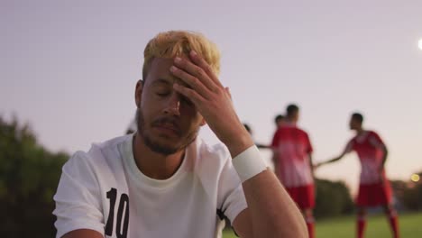 video de un jugador de fútbol biracial loco sentado en el campo