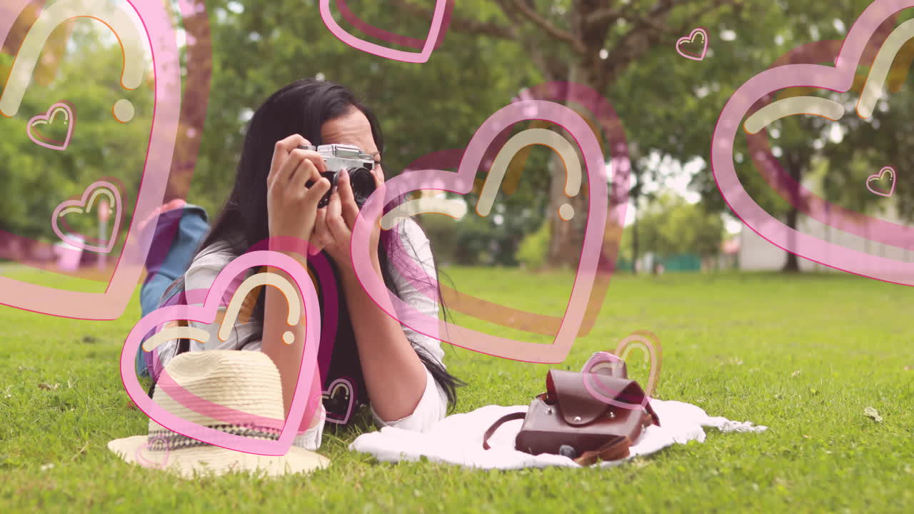 Woman taking photos in park with pink heart animation overlay