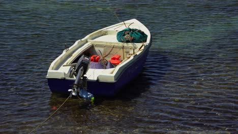 barco de pesca vacío aislado estacionado en agua de mar poco profunda cerca de la costa