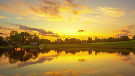 Timelapse-of-a-lake-at-sunset-with-the-sky-and-clouds-reflecting-in-the-water