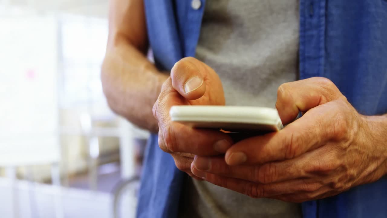 sección media de ejecutivo de negocios masculino mensajes de texto en el teléfono móvil