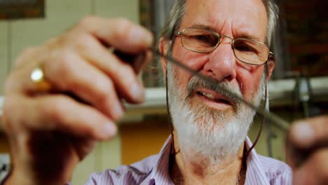 goldsmith examining metal in workshop 4k