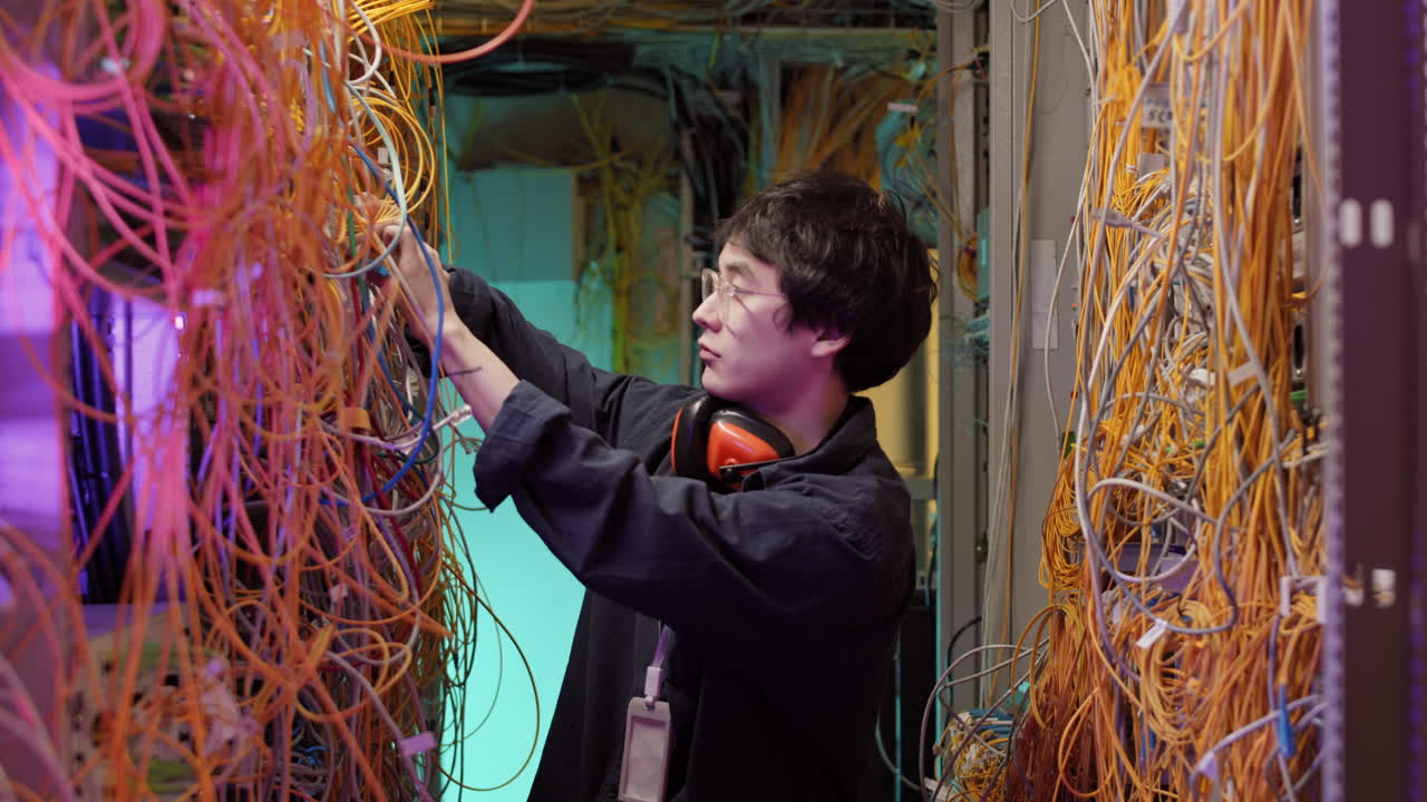 Young IT Technician Checking Server Wires