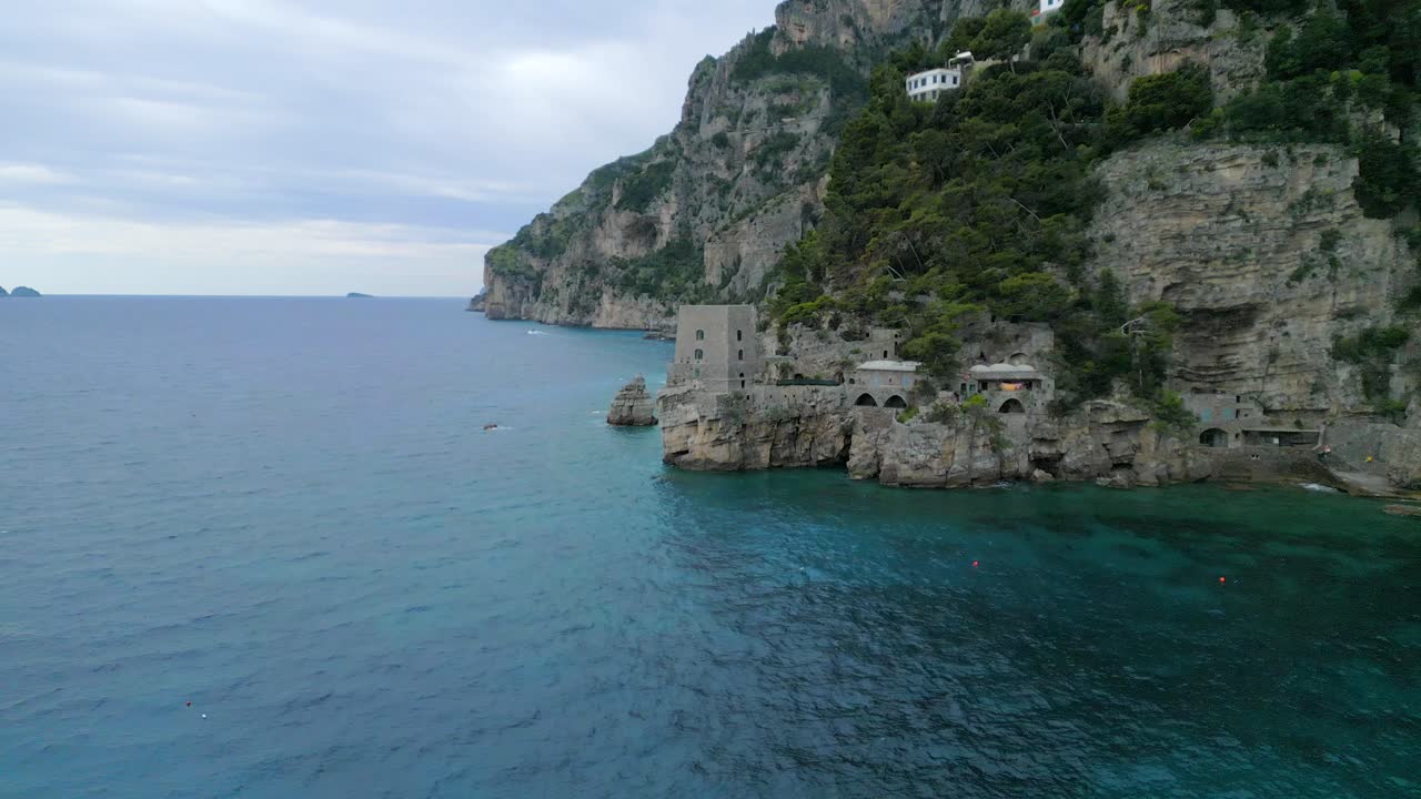 pequeño fuerte en la costa de amalfi positano italia con océano azul y rocas empinadas