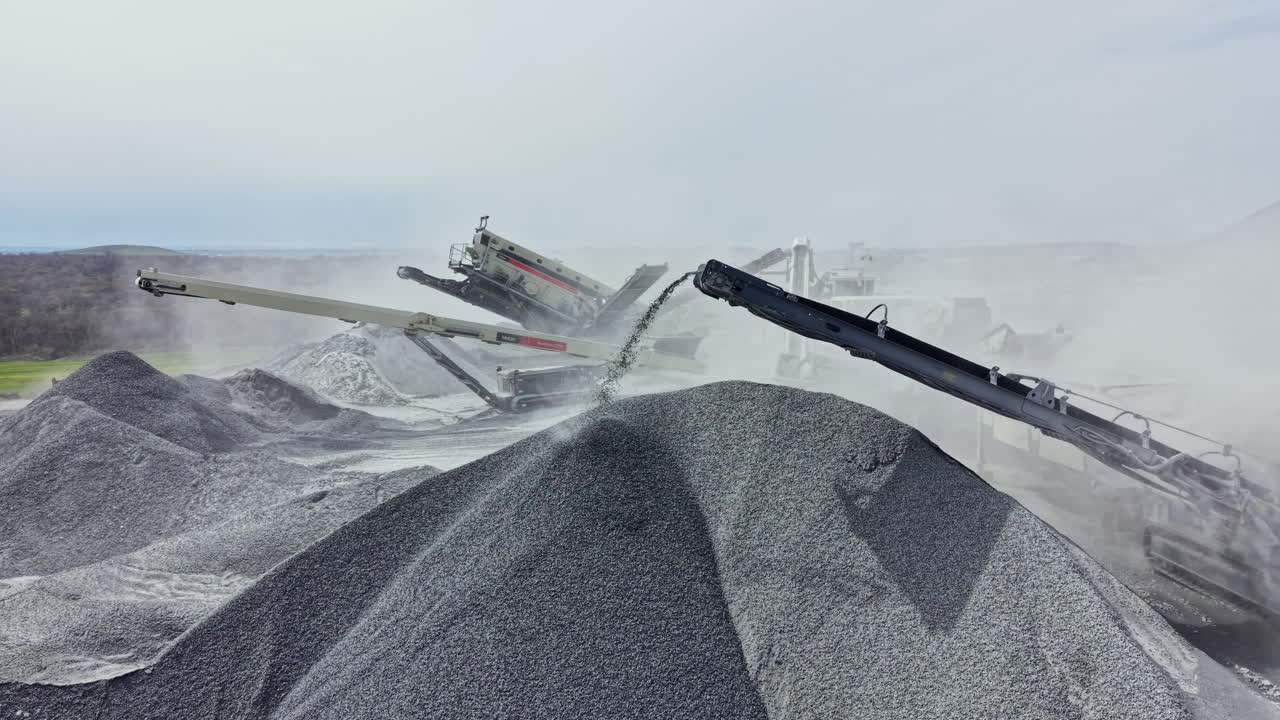 Het werk gaat door in een granietgroeve waar machines steen verwerken en de hele dag grote hopen grind creëren.