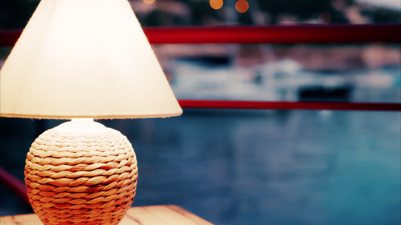 Close up view of a lamp on a table at a restaurant near a port in the south of France in the evening
