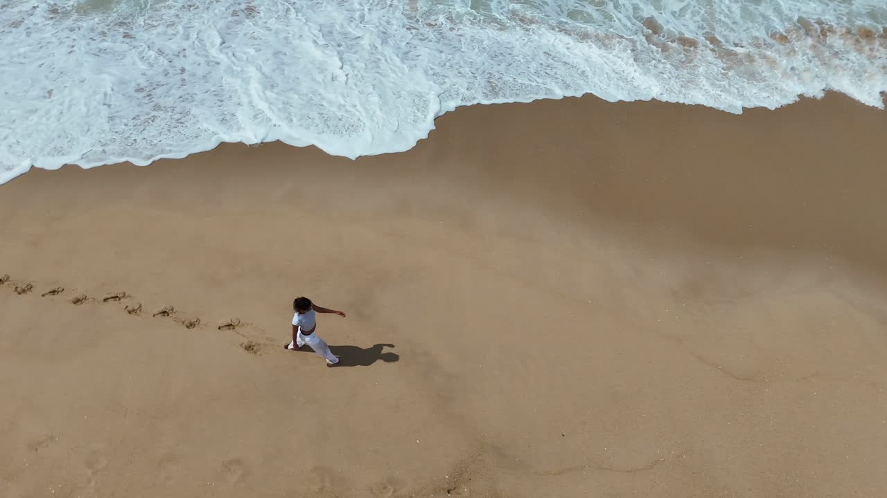 A woman walking on a sandy beach