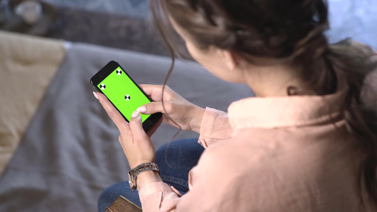 Mujer usando un teléfono con una pantalla verde.