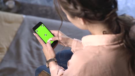 mujer usando un teléfono con una pantalla verde