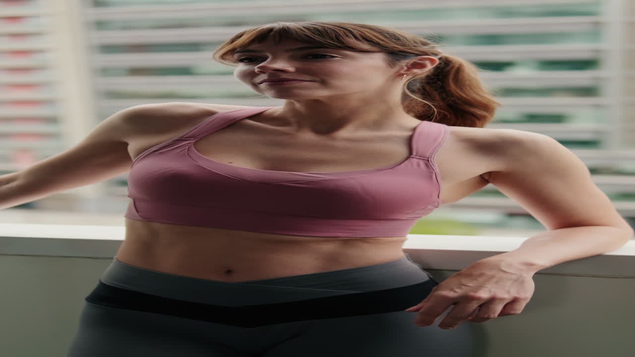 Donna in forma che mette in mostra il corpo tonico sul balcone