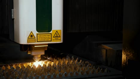 industrial cutting of iron sheets of metal using a laser machine. bright sparks of laser aperture. close-up. automatic process