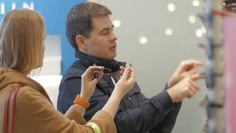 Man-and-woman-trying-on-the-glasses-at-optician