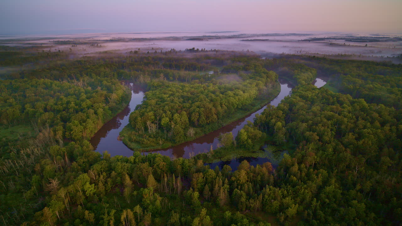 Drone footage showing the Manistee river twisting and turning while running wild through forest in northern Michigan