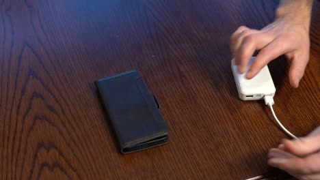 white powerbank connected to phone on wooden table