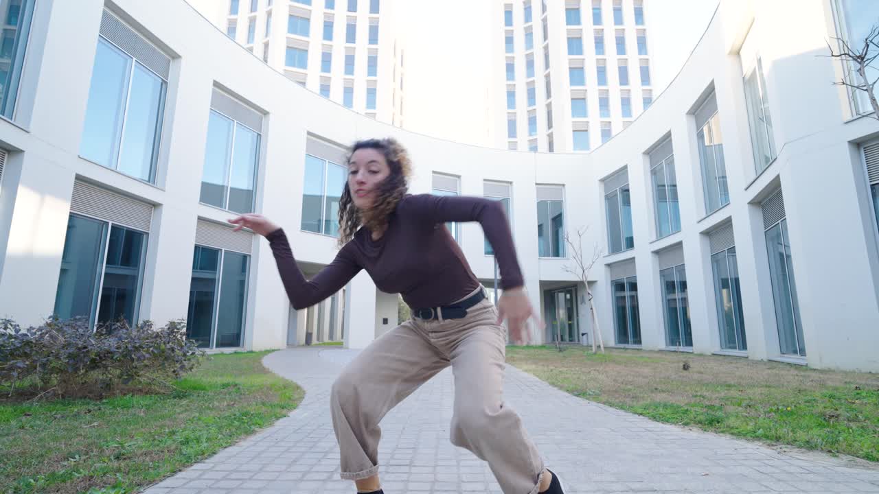 Young energetic woman dancing freestyle in modern urban setting