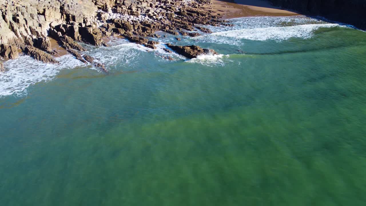 Low Flying Aerial Approaching Rocky Beach with Colorful Turquoise Sea Water. Travel Nature Drone Clip. Beautiful Welsh Gower Peninsula Coast