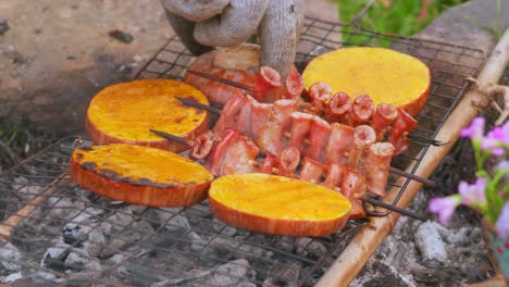 Close-up-of-a-person-turning-the-meat-and-vegetables-of-a-rustic-rural-barbecue