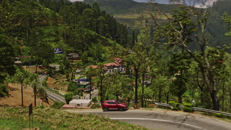 Palagolla-Sri-Lanka-Aerial-v3-flyover-A5-mountain-road-across-hillside-village-and-highland-tea-plantations,-capturing-mountainous-landscape-and-Kotmale-reservoir---Shot-with-Mavic-3-Cine---April-2023