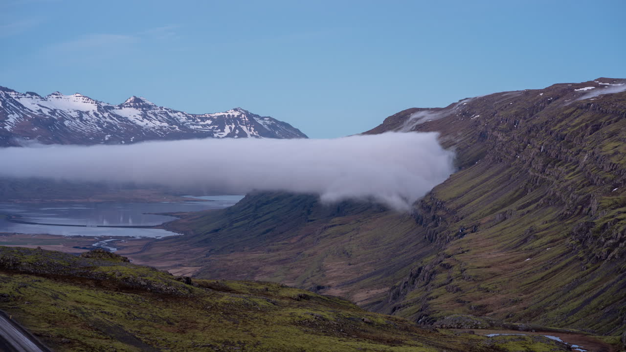 Time Lapse of Clouds Moving Above Valley and Fjord Under Snow Capped Mountains, Iceland