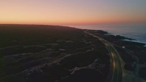breathtaking pink sunset sky over coastline drone view. road running seashore