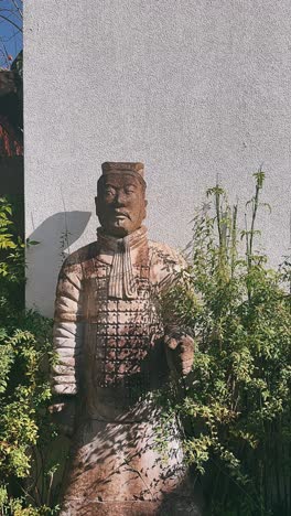 terracotta soldier statue in garden setting