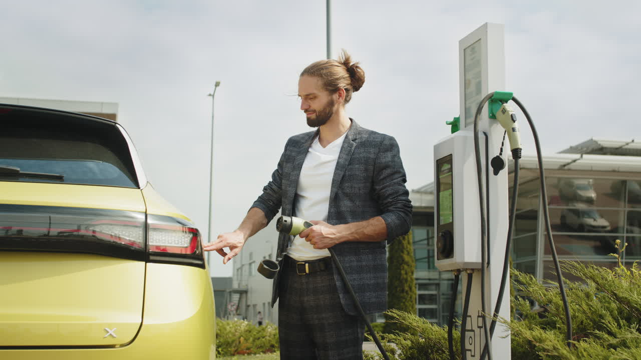 человек, заряжающий электрический автомобиль