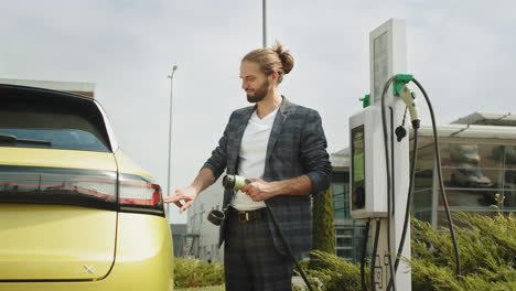 hombre cargando un vehículo eléctrico