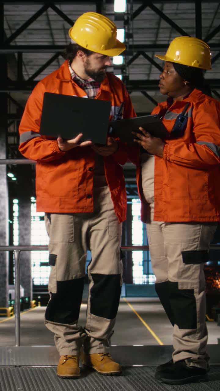 Vertical Video Professional engineers team coordinating production line in large-scale factory