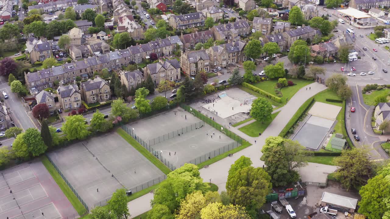 Aerial shot flying over tennis club and courts in English housing estate