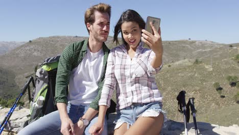 Smiling-couple-taking-selfie-in-mountains