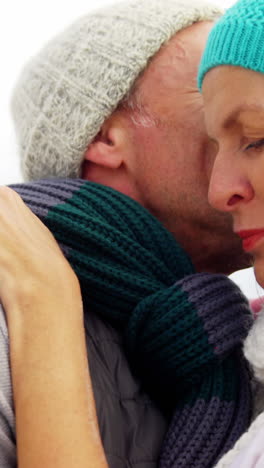 senior man kissing senior woman on cheeks