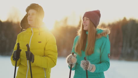 en el bosque invernal al atardecer, un hombre y una mujer esquían y contemplan la belleza de la naturaleza y las atracciones en cámara lenta.