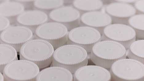 looped spinning close-up background of white high density polyethylene plastic bottle caps