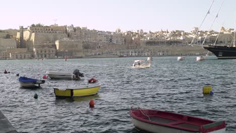 una pequeña góndola llega al puerto desde valletta, malta en bg