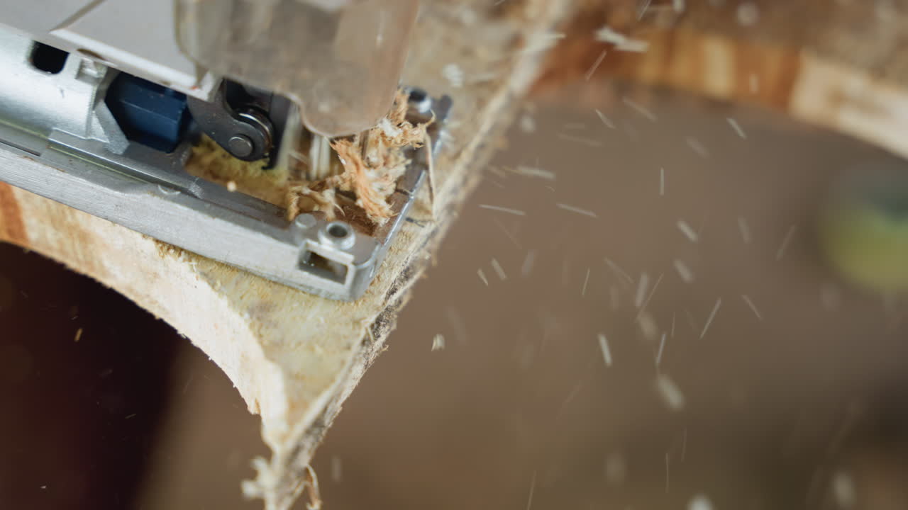 Closeup jigsaw cutting curved plywood edge, sawdust spraying, dynamic workshop energy, cabinetmaker shaping shelf profile, flying chips and debris, revealing smooth rounded contour, rapid precise cut
