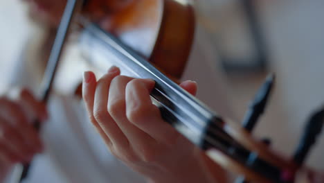 teenage girl hand playing violin. woman fingers pressing strings on violin