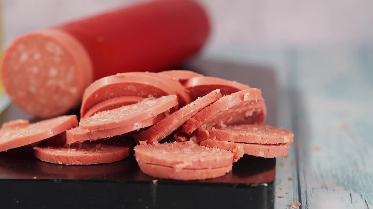 Primo piano di salame affettato su un tagliere nero