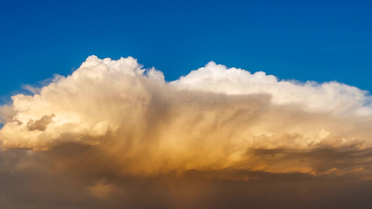Warm sunset tones lighting up drifting clouds in a dramatic sky scene
