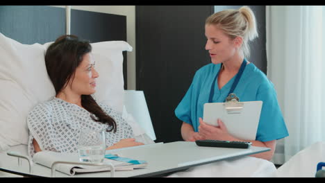 female patient in hospital bed being served meal by orderly